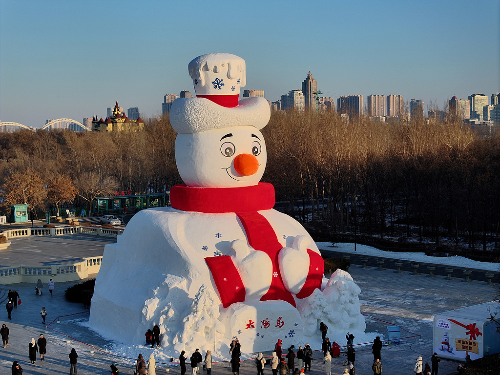 Tourists take photos with a giant snowman at the Harbin Sun Island International Snow Sculpture Art Expo in Heilongjiang, China, on December 10, 2025. /CFP