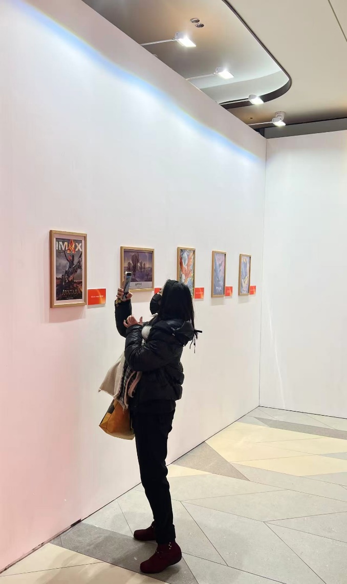 A visitor is seen taking a picture of the IMAX posters of 