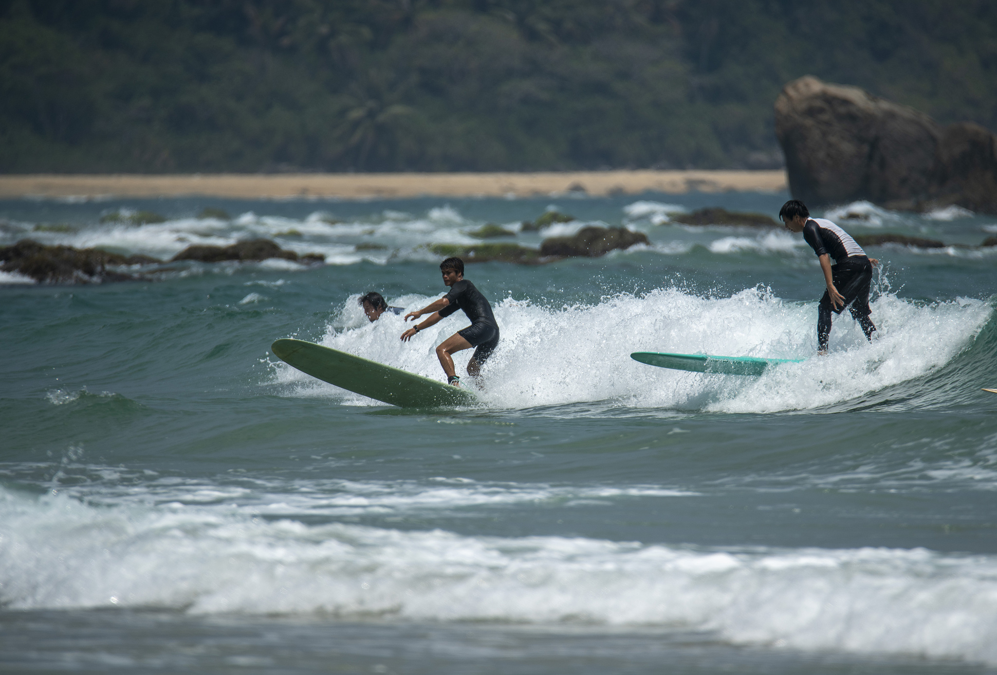 Tourists surfing at Riyue Bay in Wanning, Hainan Province. /CFP