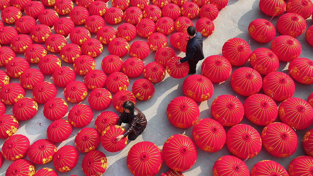 Workers arrange rows of freshly-made red lanterns at a workshop in a village in Shanxi Province, December 10, 2025. /VCG