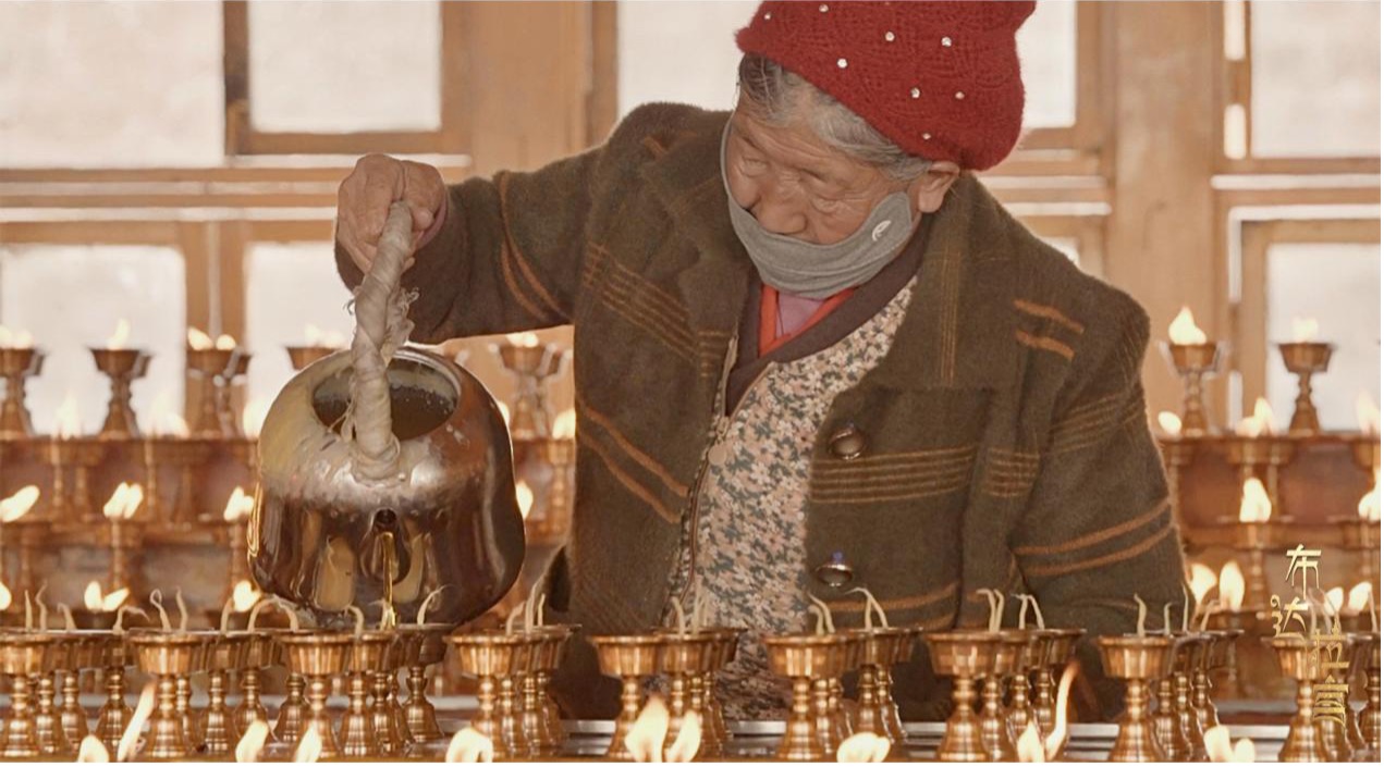 A believer pours melted yak butter into lamp holders during the Butter Lamp Festival at the Sera Monastery in Lhasa, Xizang Autonomous Region, December 14, 2025. /CGTN