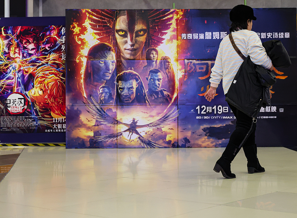 A moviegoer passes by a poster for 