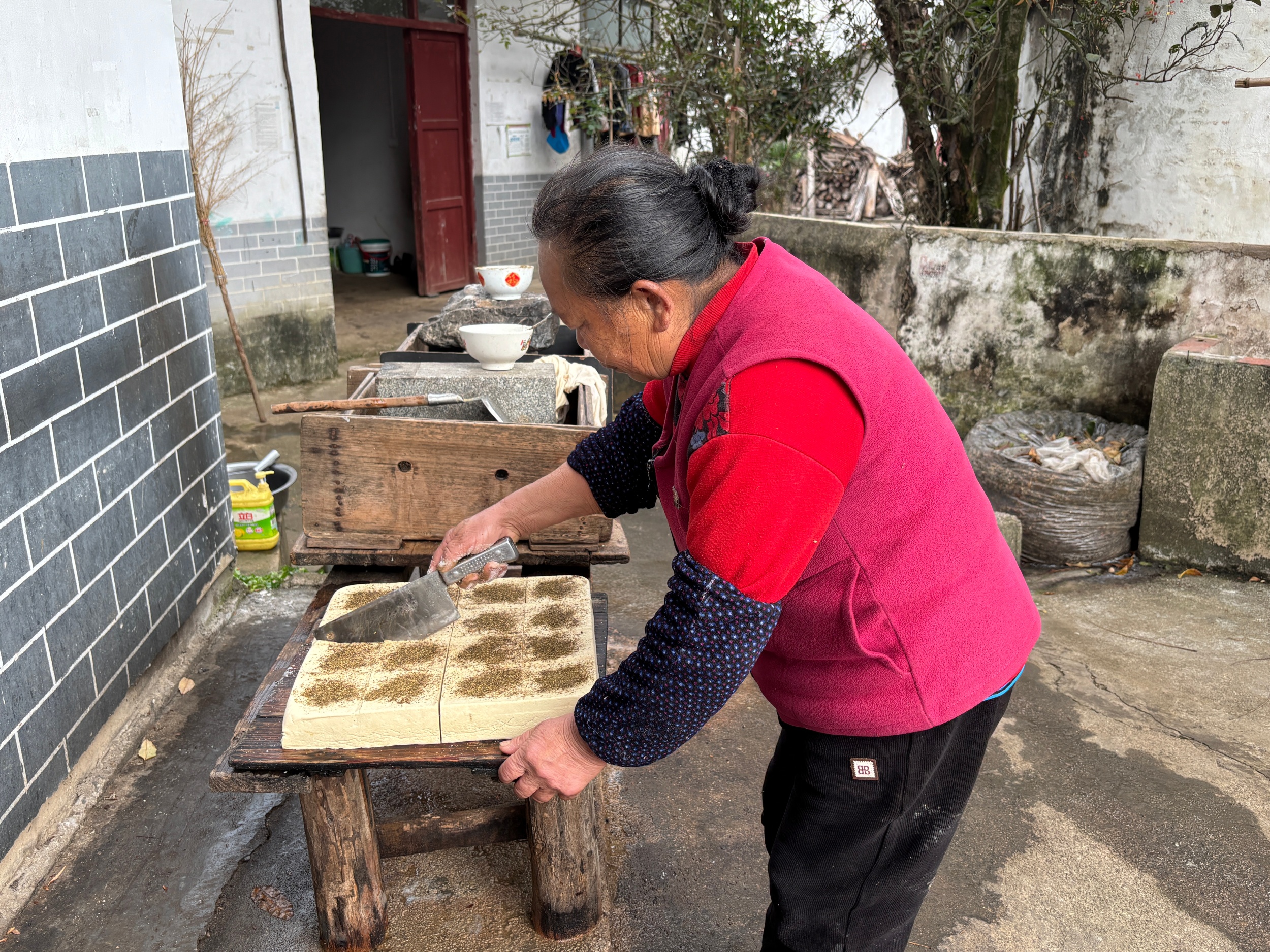 A woman makes traditional smoked tofu in Laozhai Village, Yuping Dong Autonomous County, southwest China's Guizhou Province, on December 17, 2025. /Tongren Media Convergence Center