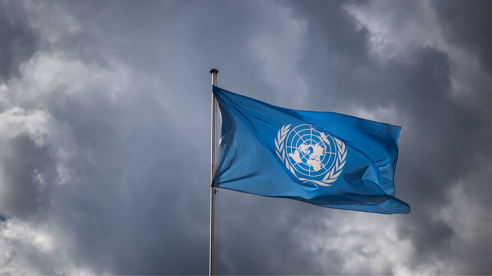 A file photo of the United Nations (UN) flag waves under a cloudy sky at the United Nations Offices in Geneva. /VCG