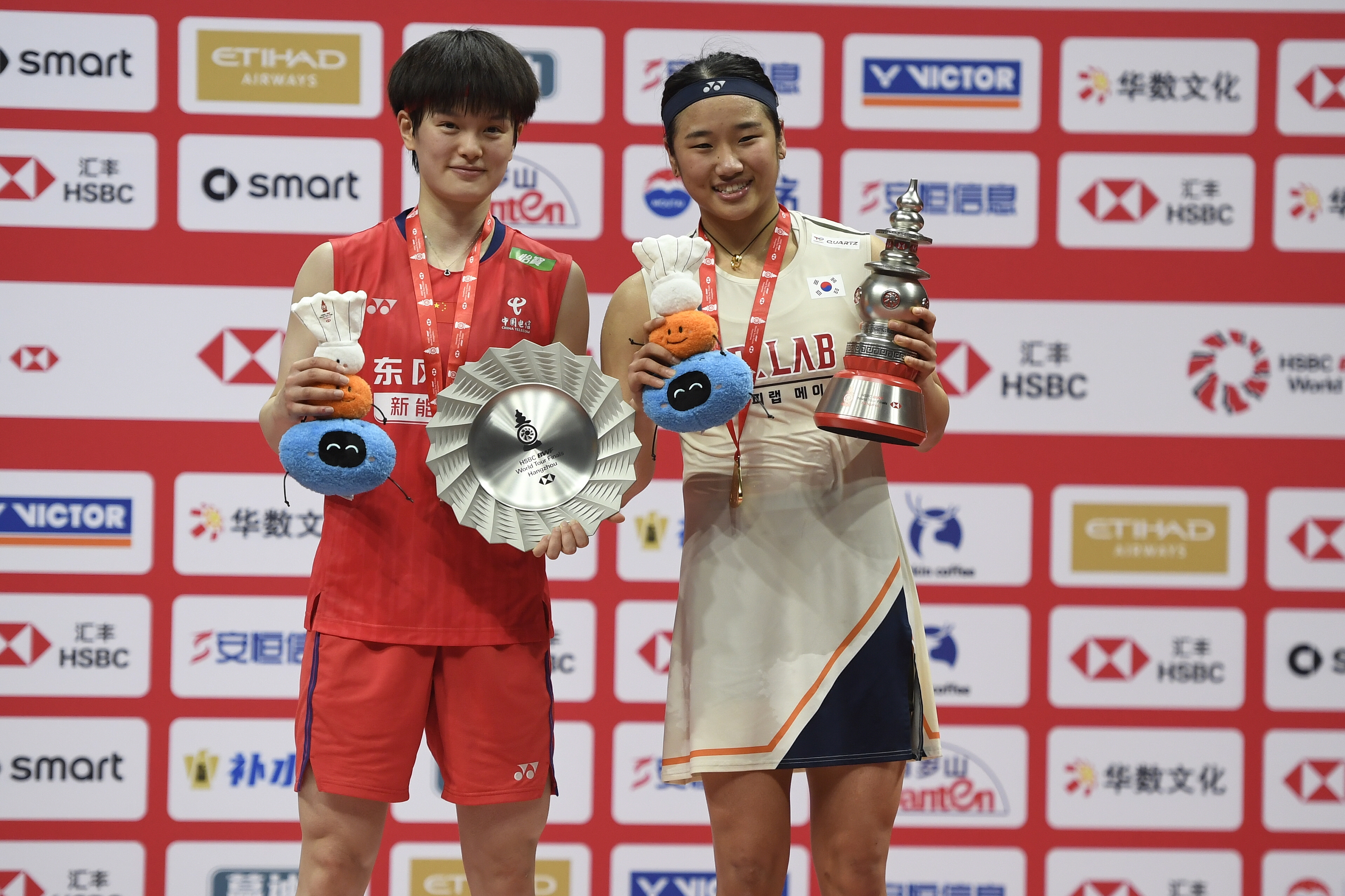 Gold medalist An Se-young (R) from the Republic of Korea displays her awards alongside silver medalist Wang Zhiyi (L) of China after the women's singles final at the BWF World Tour Finals in Hangzhou, China, December 21, 2025. /VCG
