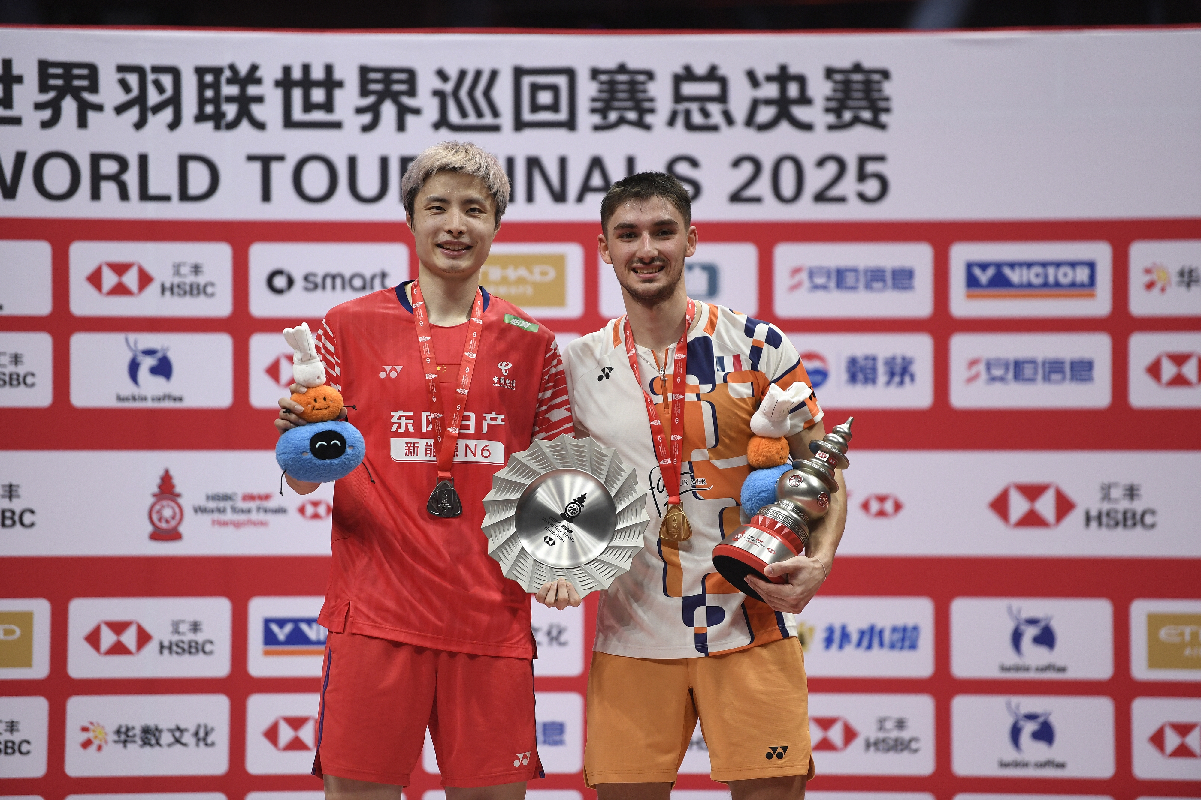 Gold medalist Christo Popov (R) of France displays his awards alongside silver medalist Shi Yuqi (L) of China after the men's singles final at the BWF World Tour Finals in Hangzhou, China, December 21, 2025. /VCG