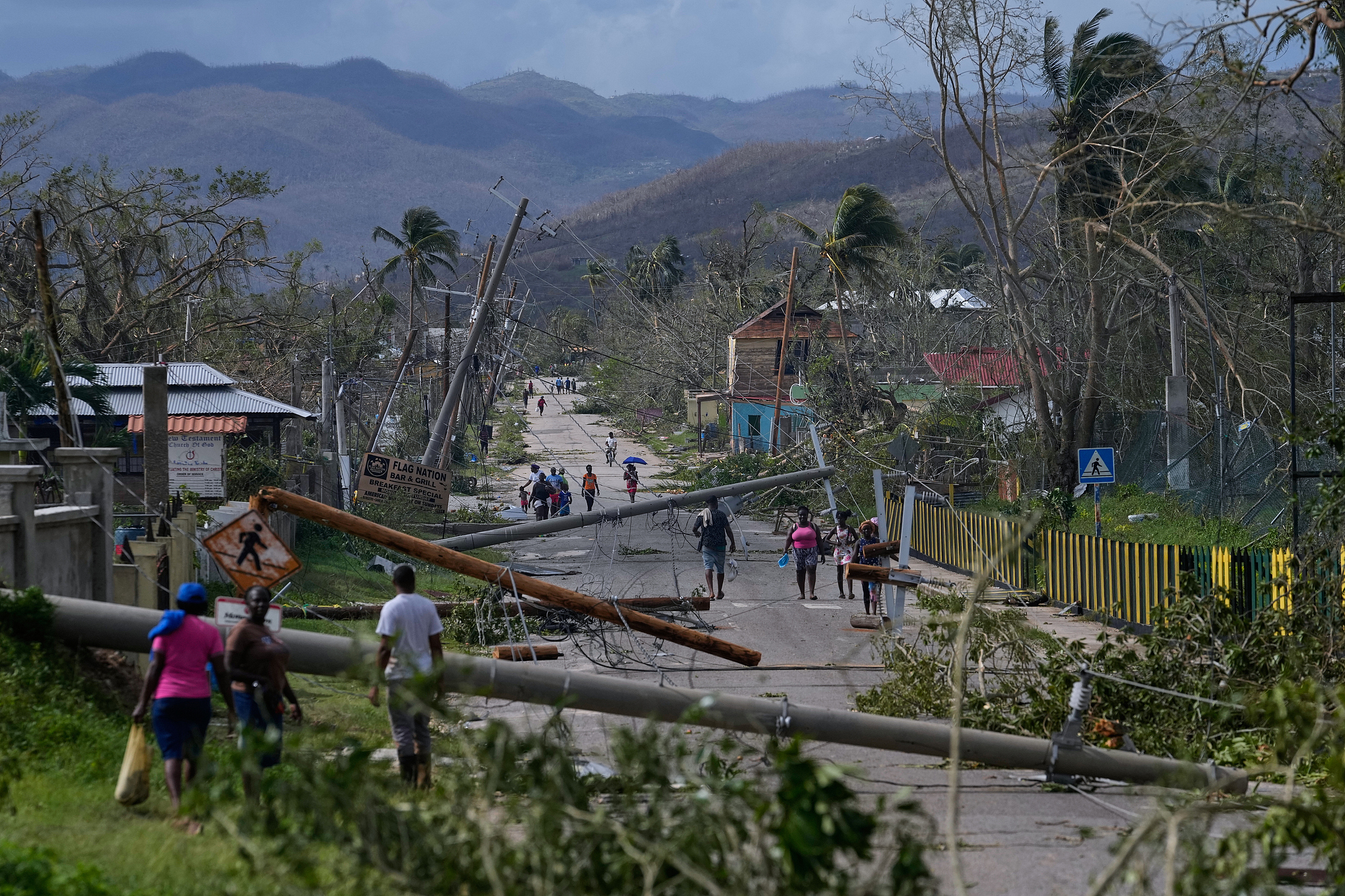 Residents walk through Lacovia Tombstone, in the aftermath of Hurricane Melissa that affects 1.5 million people in Jamaica, October 29, 2025. /VCG