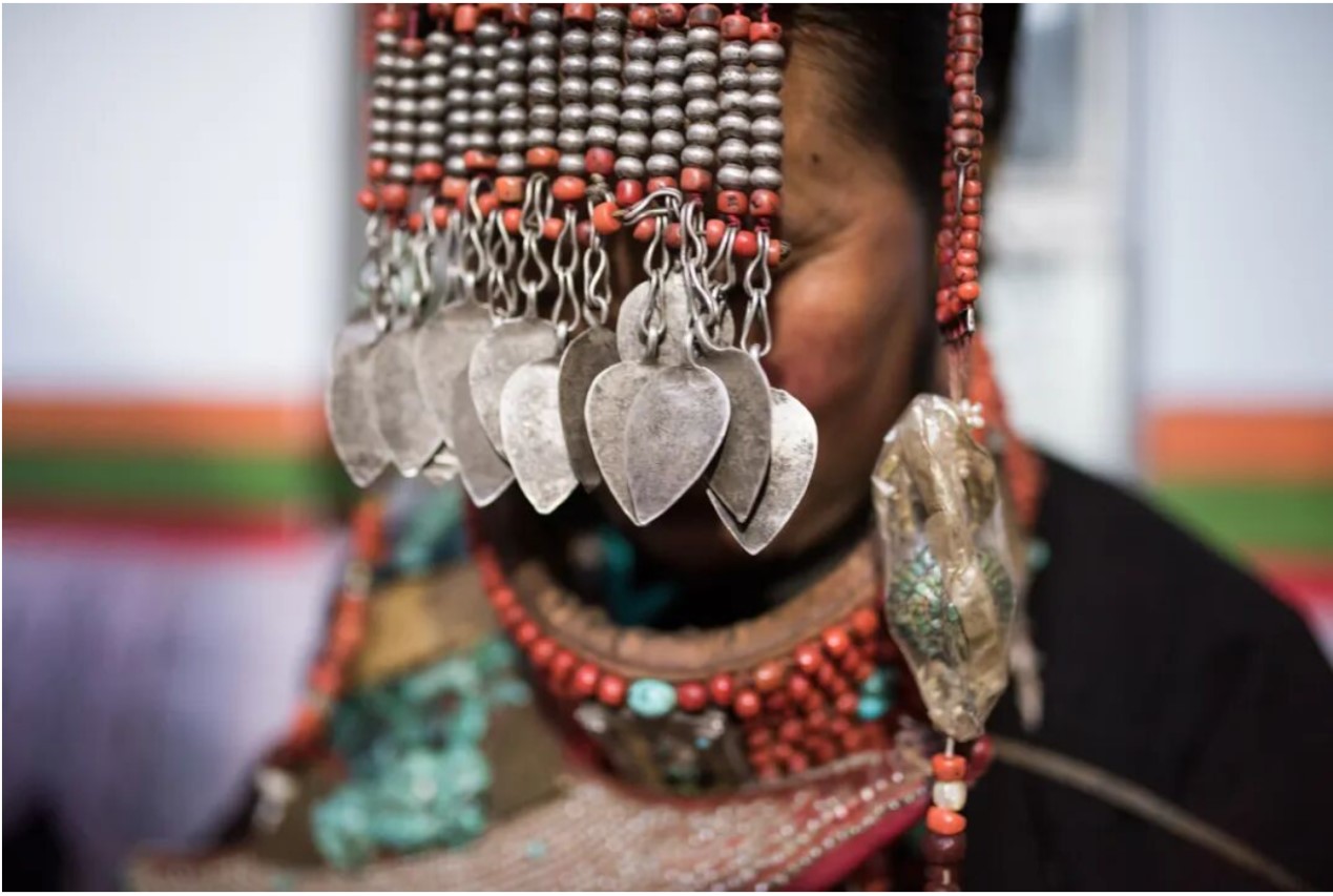 A woman is adorned in traditional Pulan dress, Xizang Autonomous Region. /CGTN