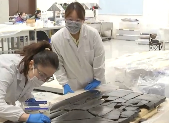 Examining instruments unearthed at the Wuwangdun tomb in Huainan City, east China's Anhui Province. /CMG