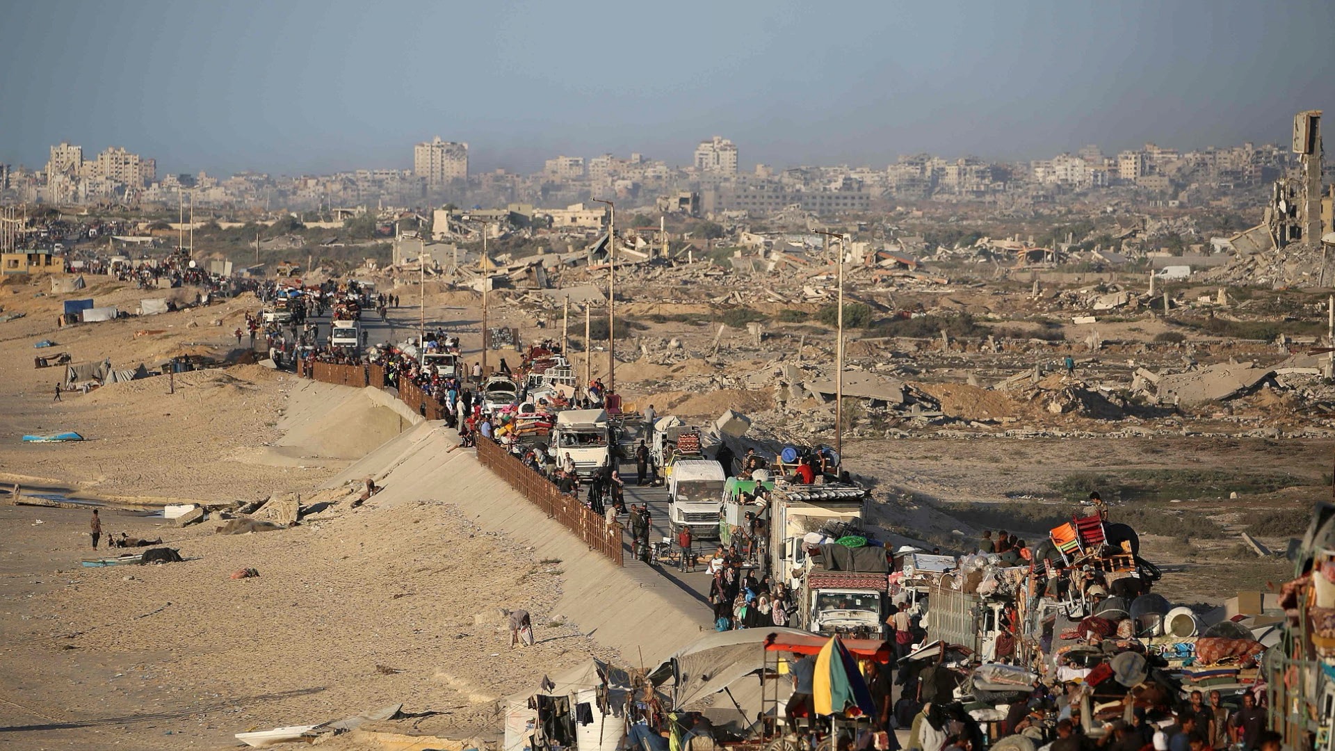 Displaced Palestinians carry their belongings along a road in the Nuseirat refugee camp in central Gaza on September 20, 2025, as Israel continues its ground offensive. /VCG