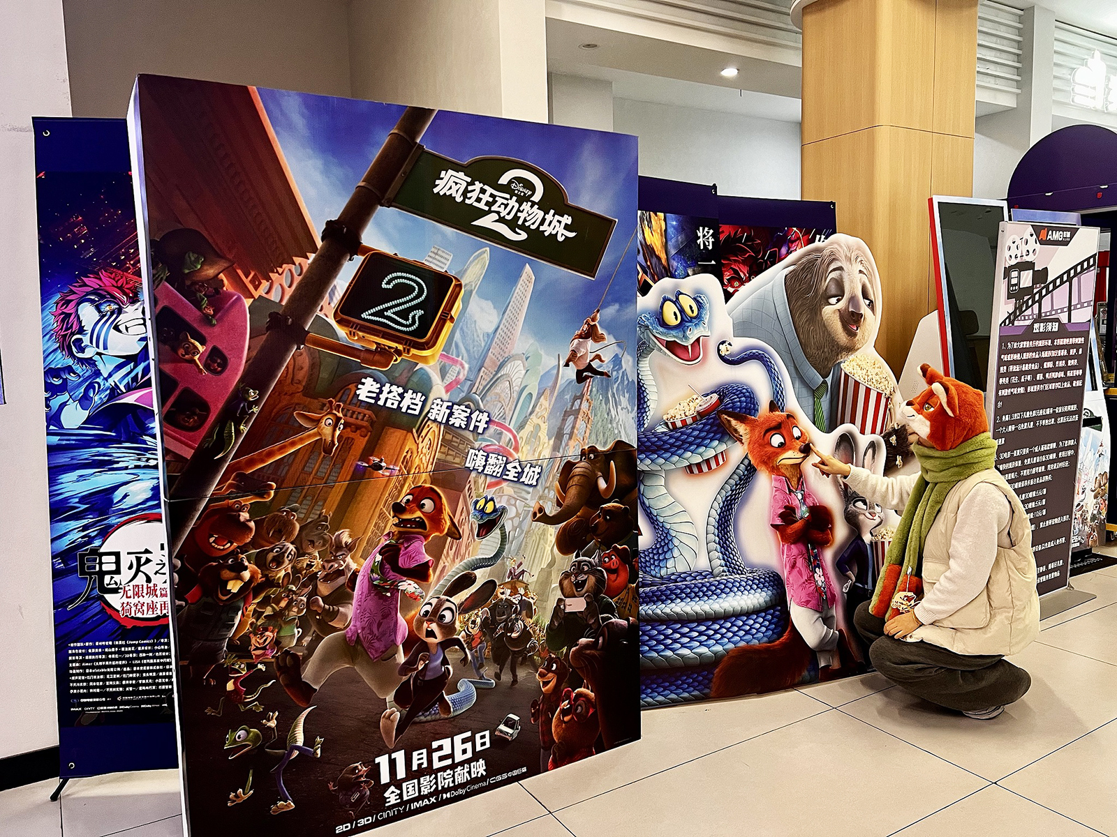 A fan wearing a Nick Wilde headpiece poses with promotional displays for 