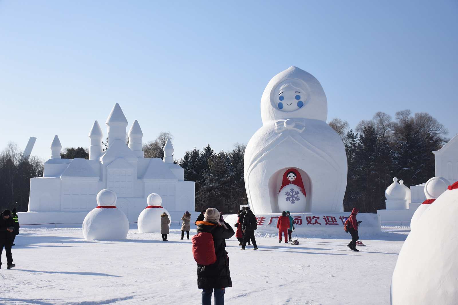 Visitors take photos of snow sculptures at the 38th Sun Island International Snow Sculpture Art Expo in Harbin, Heilongjiang Province during a trial run on December 27, 2025. /VCG