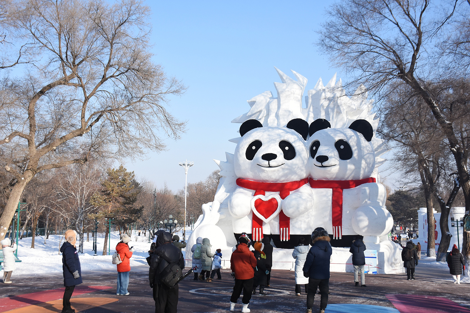Visitors take photos of snow sculptures at the 38th Sun Island International Snow Sculpture Art Expo in Harbin, Heilongjiang Province during a trial run on December 27, 2025. /VCG