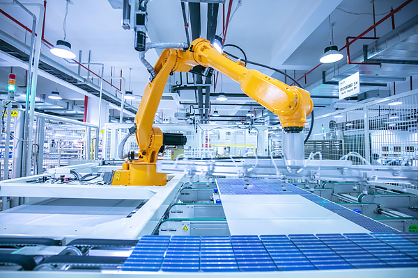 Industrial robotic arm automating the production of solar panels on a modern factory assembly line. /VCG