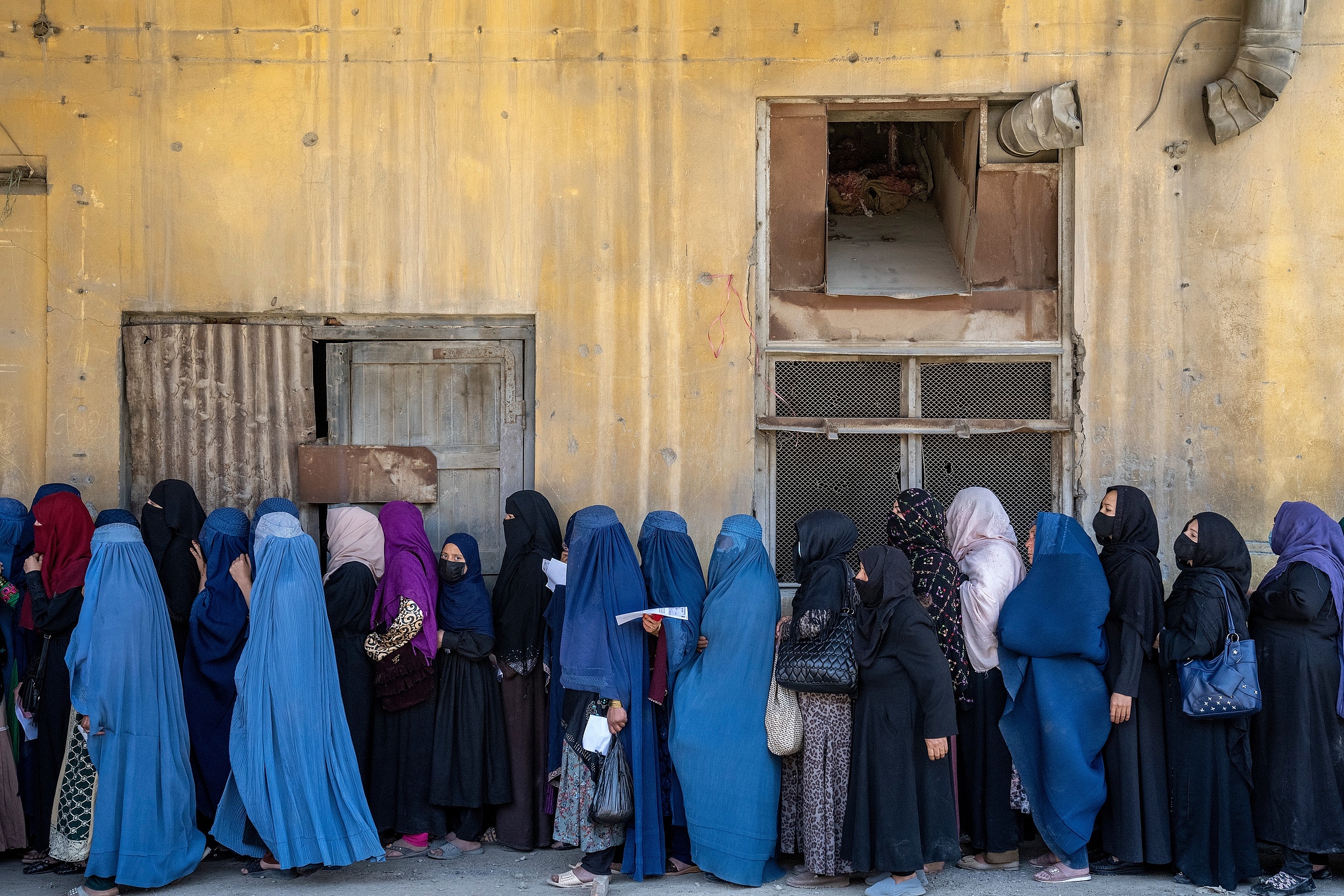 Afghan women wait to receive food rations distributed by a humanitarian aid group, in Kabul, Afghanistan, Sunday, May 28, 2023. /VCG