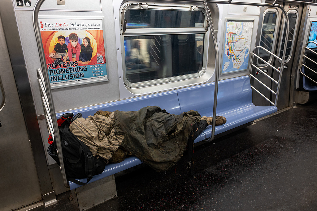 A homeless person sleeps in a subway car on December 29, 2025 in New York City. /VCG