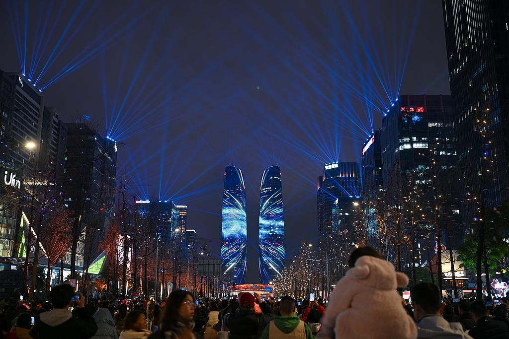 People welcome 2026 in front of the city's landmark Tianfu Twin Towers, which staged a light show on New Year's Eve, Chengdu City, southwest China's Sichuan Province, December 31, 2025. /VCG