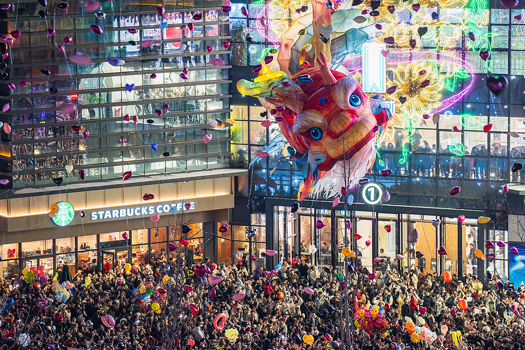 Thousands of people watch the performance of a giant floating Aoyu fish lantern at the plaza of a commercial complex in Enshi, central China's Hubei Province, on December 31, 2025. /VCG