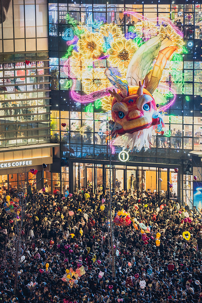 Thousands of people watch the performance of a giant floating Aoyu fish lantern at the plaza of a commercial complex in Enshi, central China's Hubei Province, on December 31, 2025. /VCG