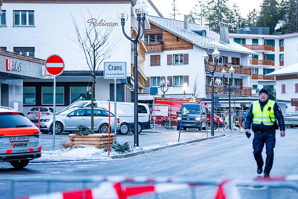 A police officer walks near ambulances at the site of an explosion that ripped through a bar in Crans-Montana, Switzerland, January 1, 2026. /AFP