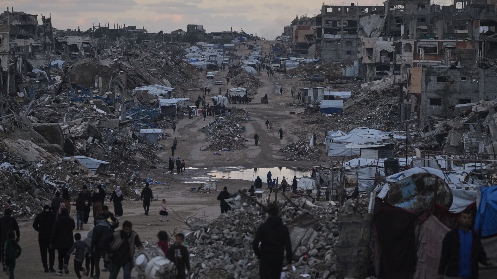 Palestinians walk past destroyed buildings in the northern Gaza Strip on January 2, 2026. /VCG