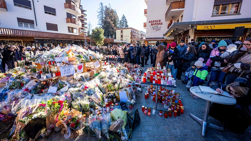 People gather around a makeshift memorial to pay their respects by laying flowers, candles and messages near the Constellation bar in Crans-Montana in honor of the victims of the fire that ripped through the venue in the Alpine ski resort on New Year's Eve in Switzerland, January 4, 2026. /VCG