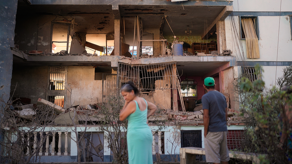 Residents look at a damaged apartment complex that neighbors say was hit during U.S. strike in Catia La Mar, Venezuela, January 4, 2026. /VCG