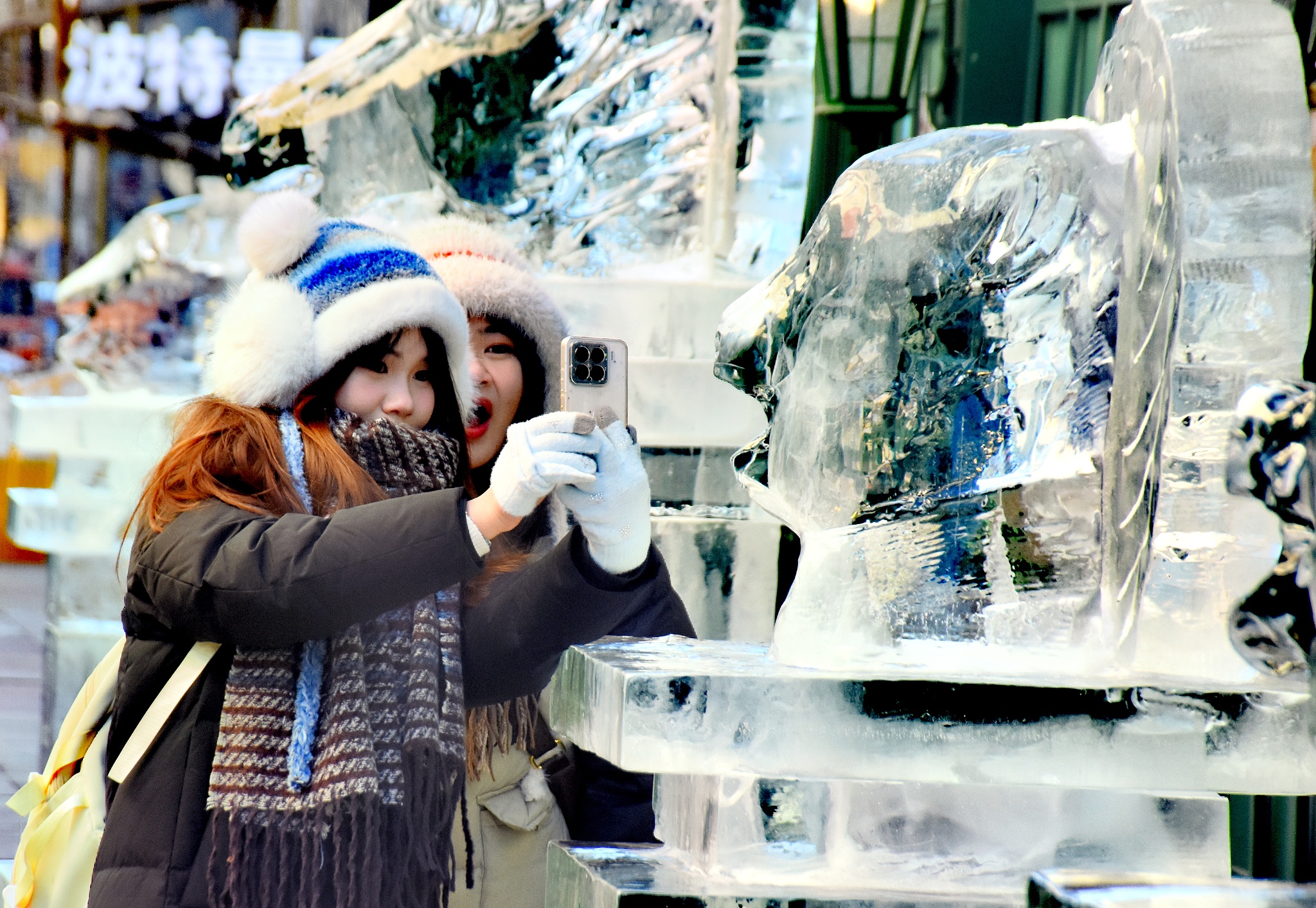 A visitor takes photos of a Chinese zodiac-themed ice sculpture in Harbin, Heilongjiang Province on January 4, 2026. /VCG