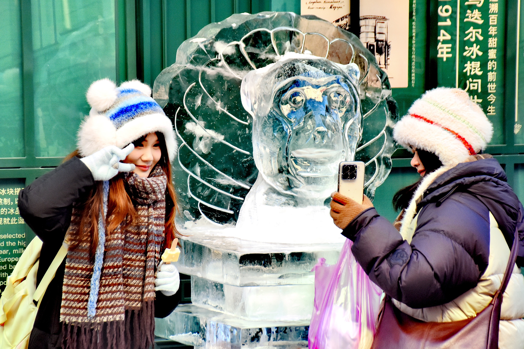 A visitor poses for photos with one of the Chinese zodiac-themed ice sculptures in Harbin, Heilongjiang Province on January 4, 2026. /VCG