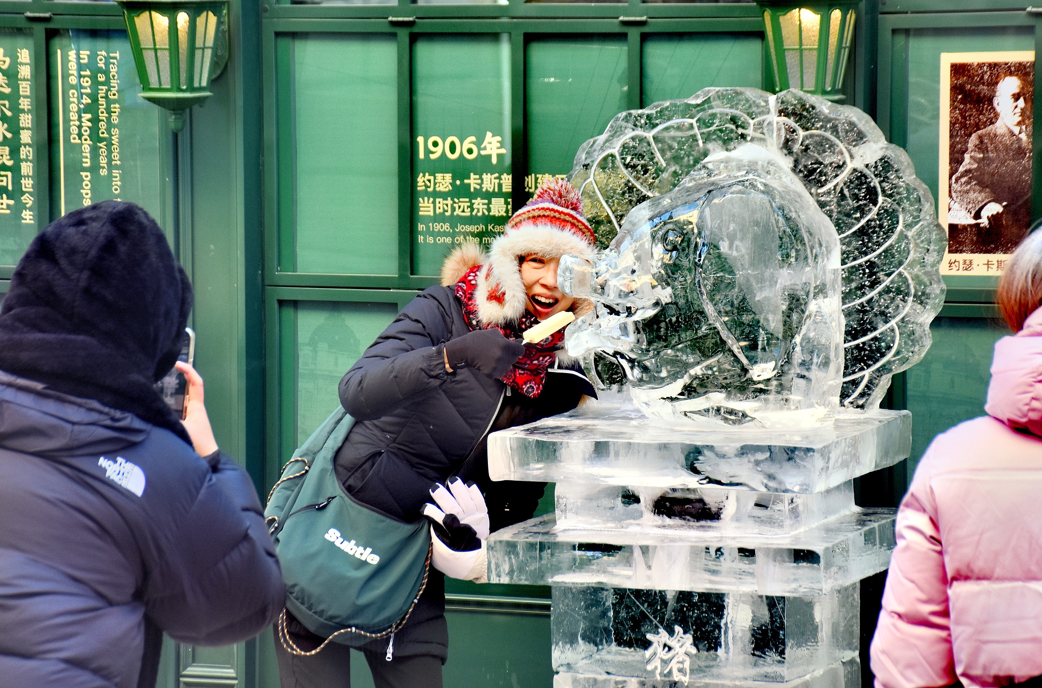 A visitor poses for photos with one of the Chinese zodiac-themed ice sculptures in Harbin, Heilongjiang Province on January 4, 2026. /VCG