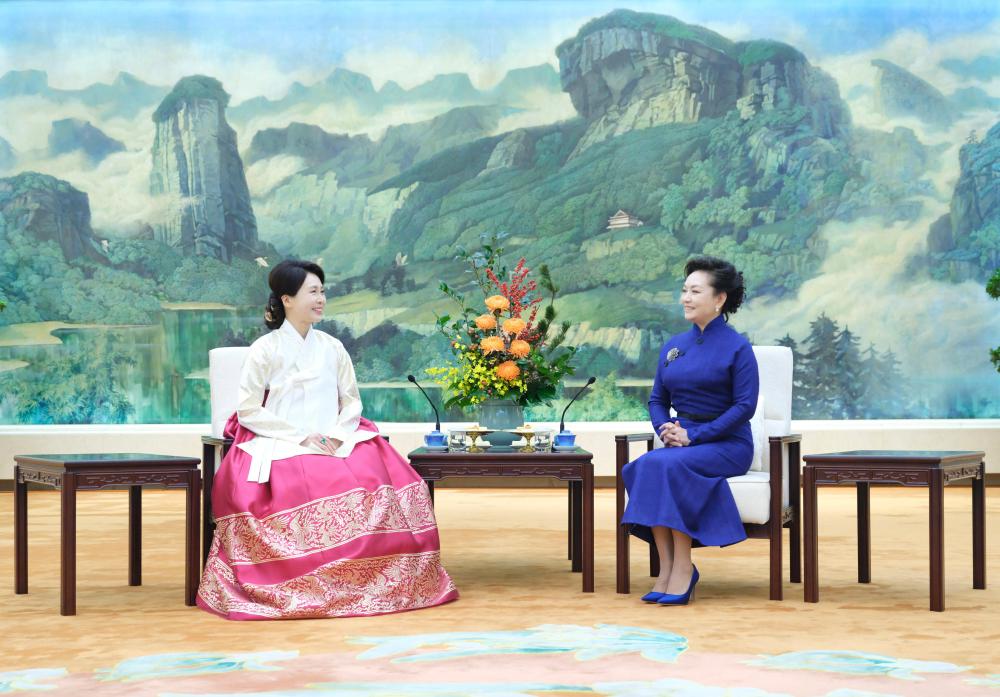 Peng Liyuan(R), wife of Chinese President Xi Jinping, chats over tea with Kim Hea Kyung, wife of President of the Republic of Korea (ROK) Lee Jae Myung, in Beijing, China, January 5, 2026. /Xinhua