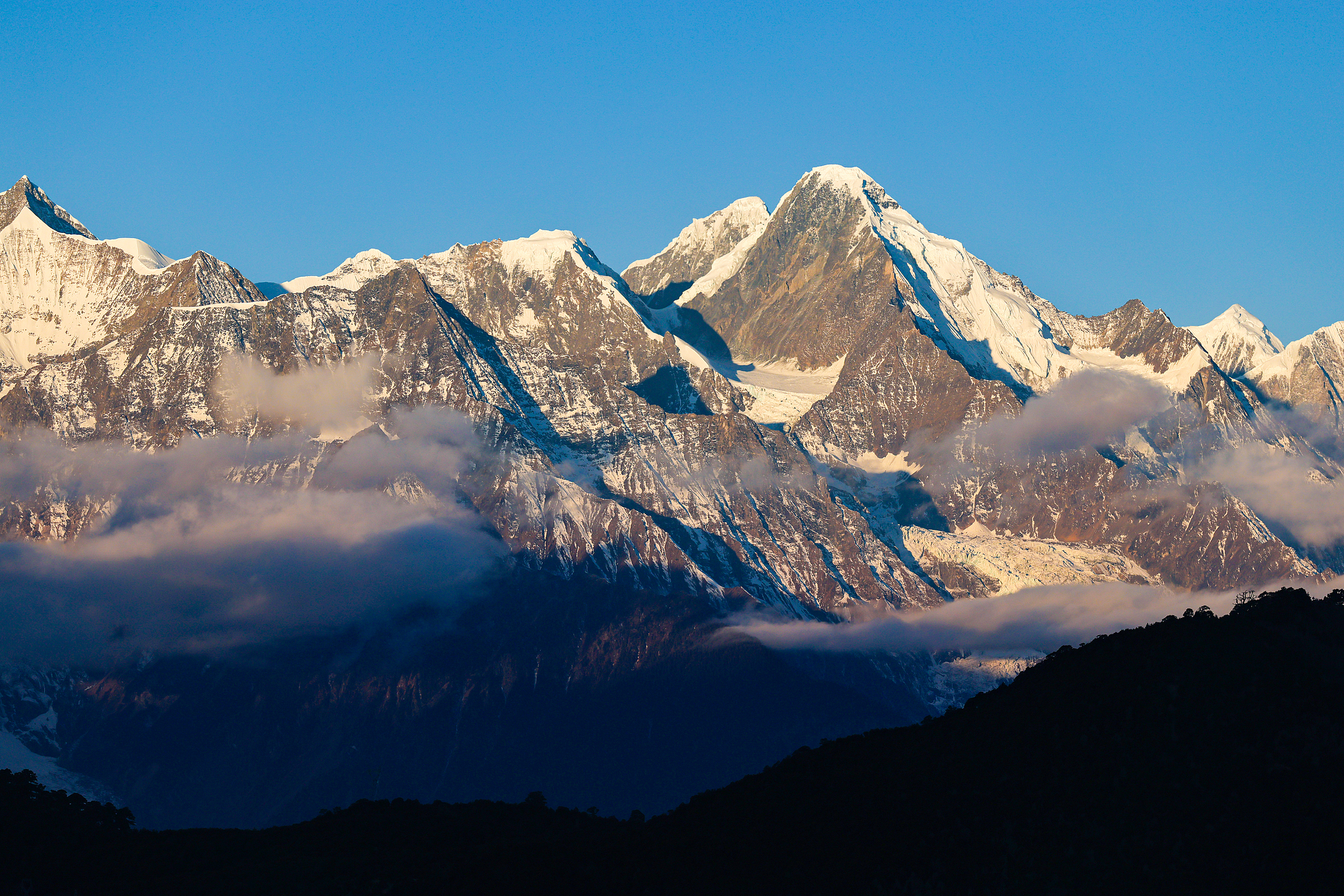 Sunlit golden peaks: Meili Snow Mountain in winter