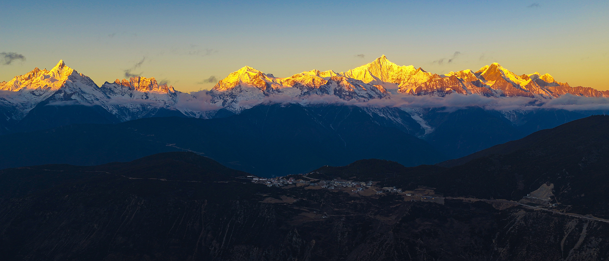 Sunlit golden peaks: Meili Snow Mountain in winter