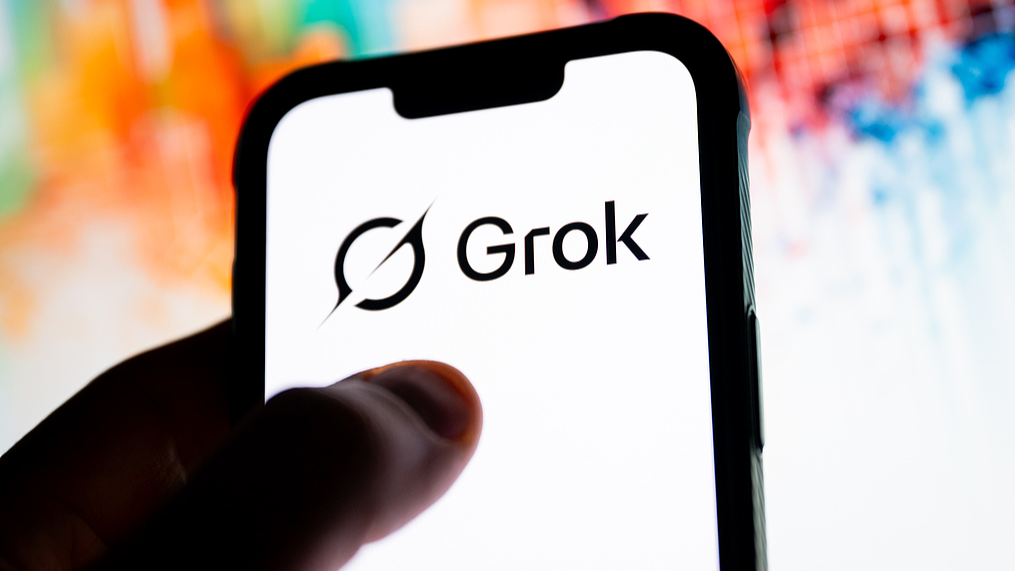 The logo of Grok is displayed on a smartphone. /VCG