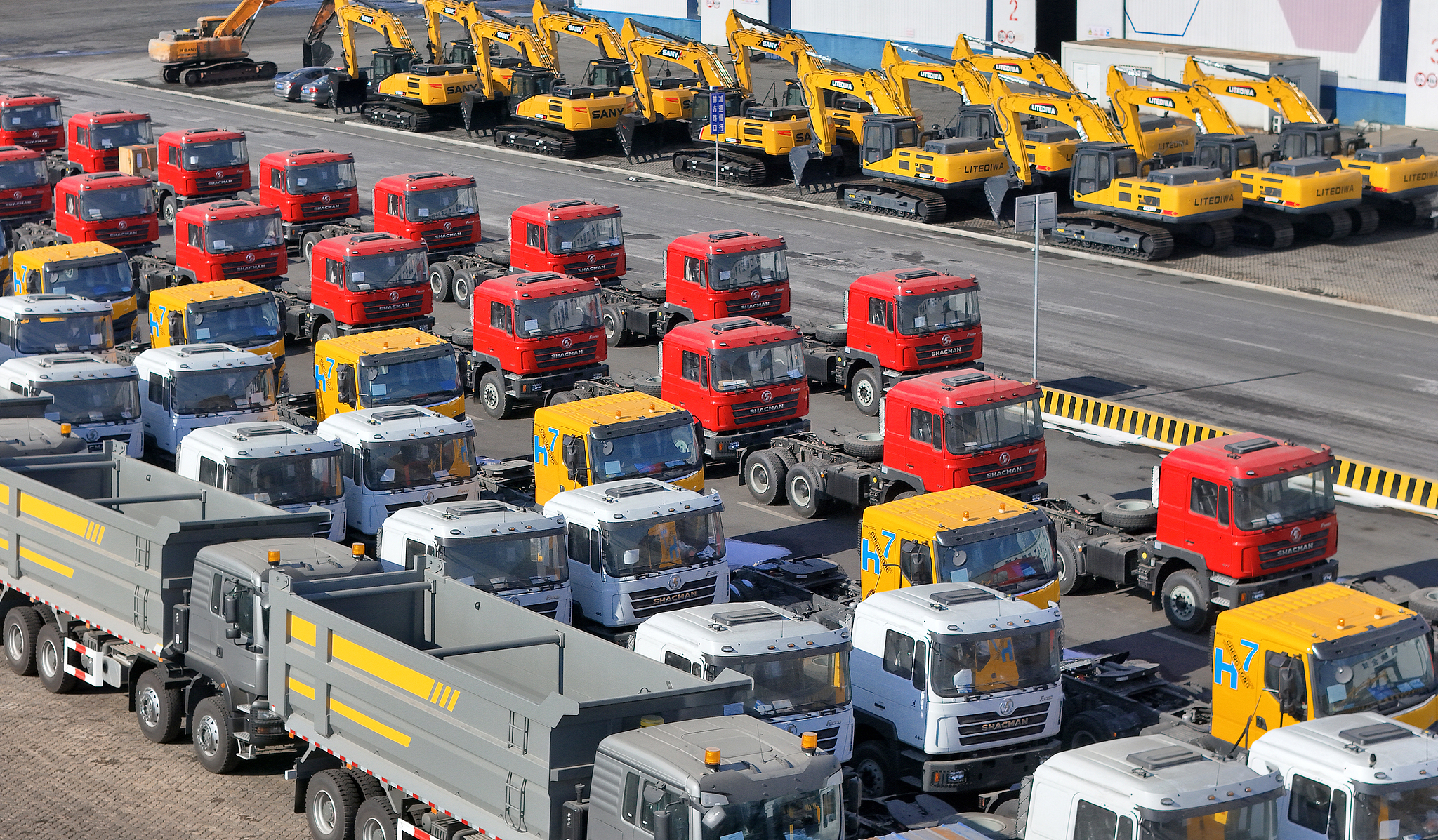 Chinese-made trucks line up at a port terminal awaiting shipment for export in Yantai, Shandong Province, China, January 13, 2026. /VCG