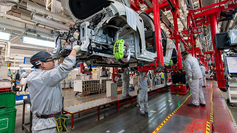 New energy vehicle factory workers tune cars on production line, Jinhua, Zhejiang Province, China, January 13, 2026. /VCG