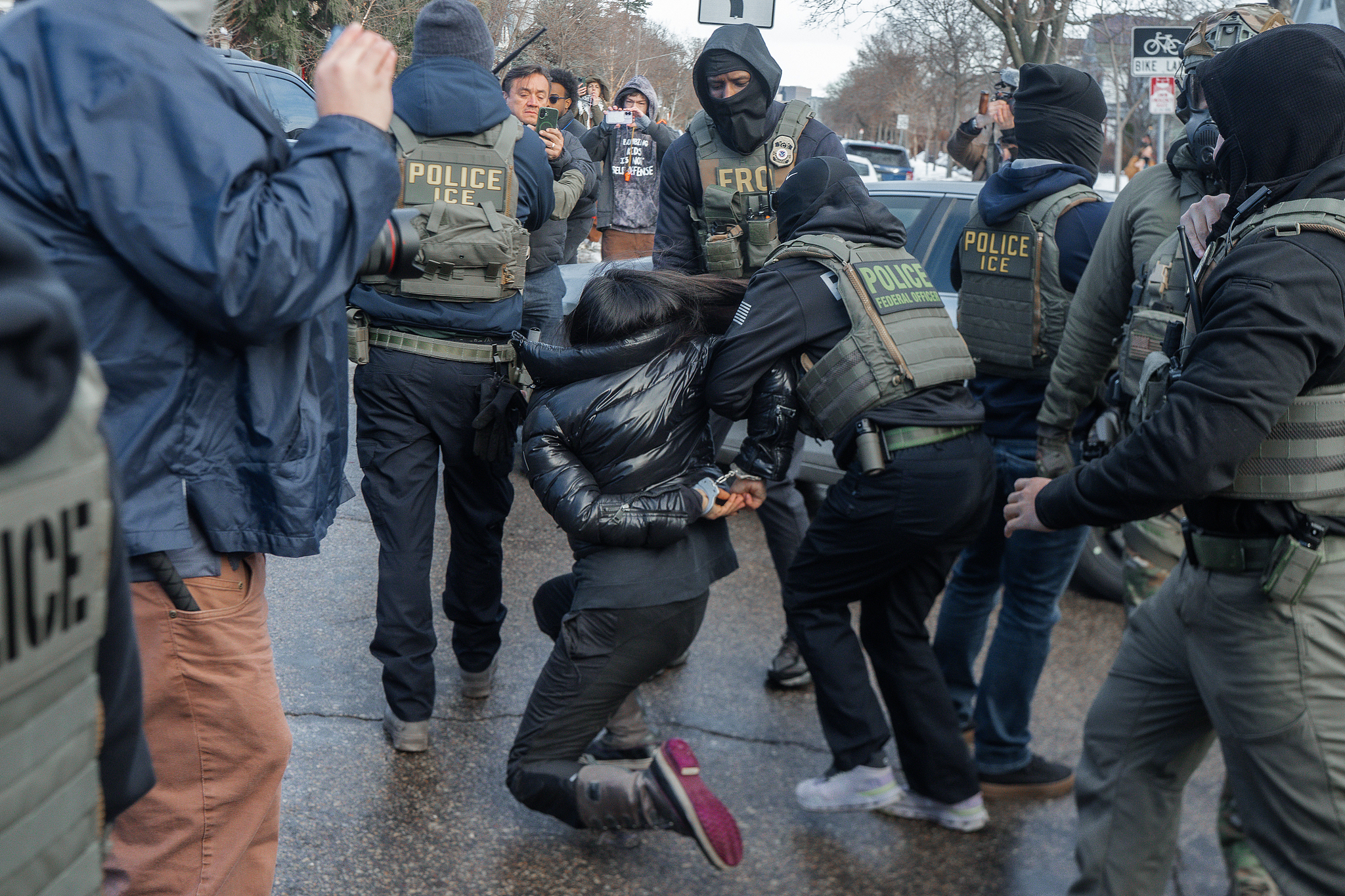 A woman stumbles and falls as federal immigration enforcement drag her after smashing the windows of her car in Minneapolis, Minnesota, U.S., January 13, 2026./VCG