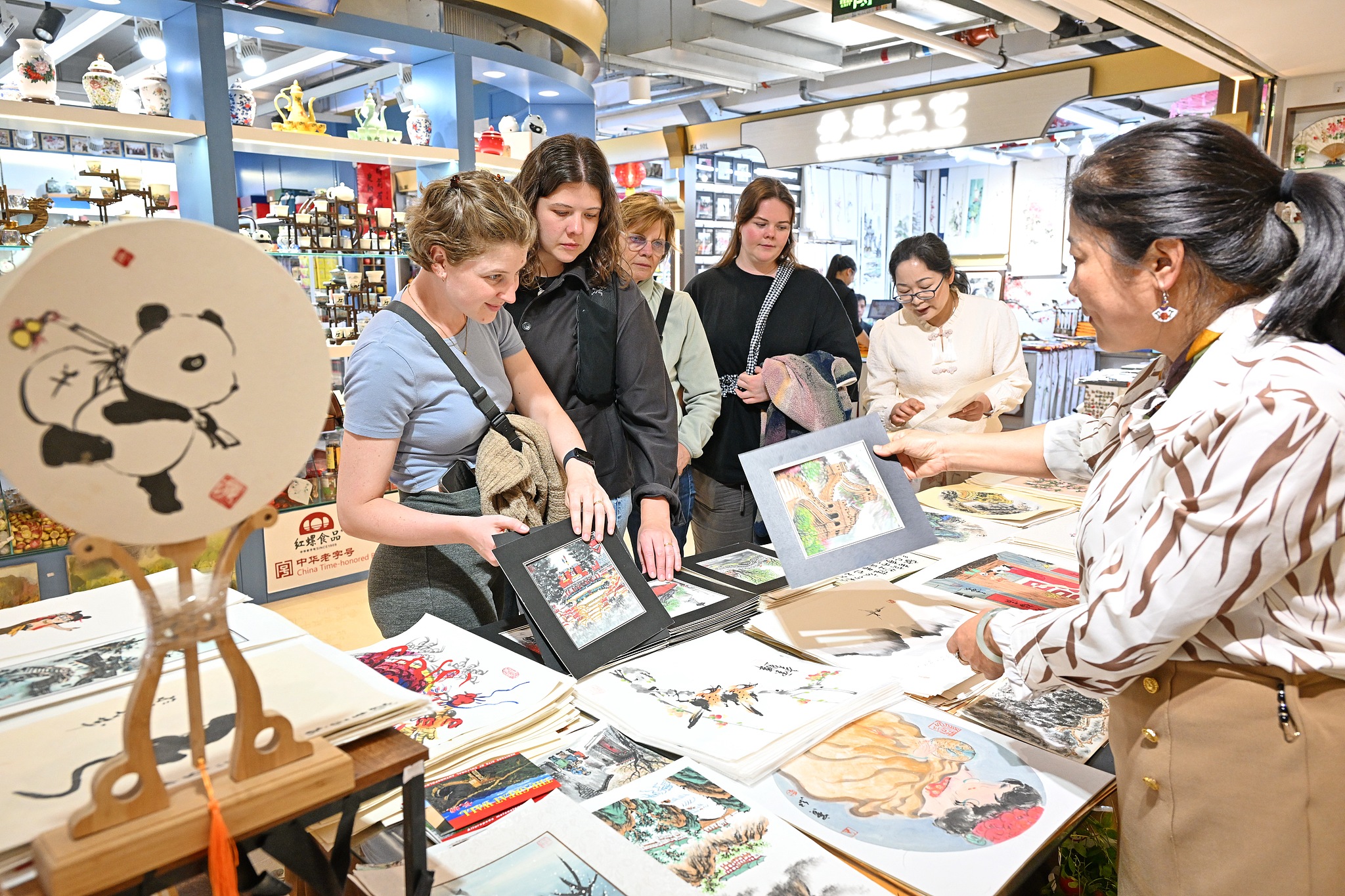 Tourists purchase Chinese paintings at the Silk Street Shopping Center in Beijing, China, April 20, 2025. /CFP