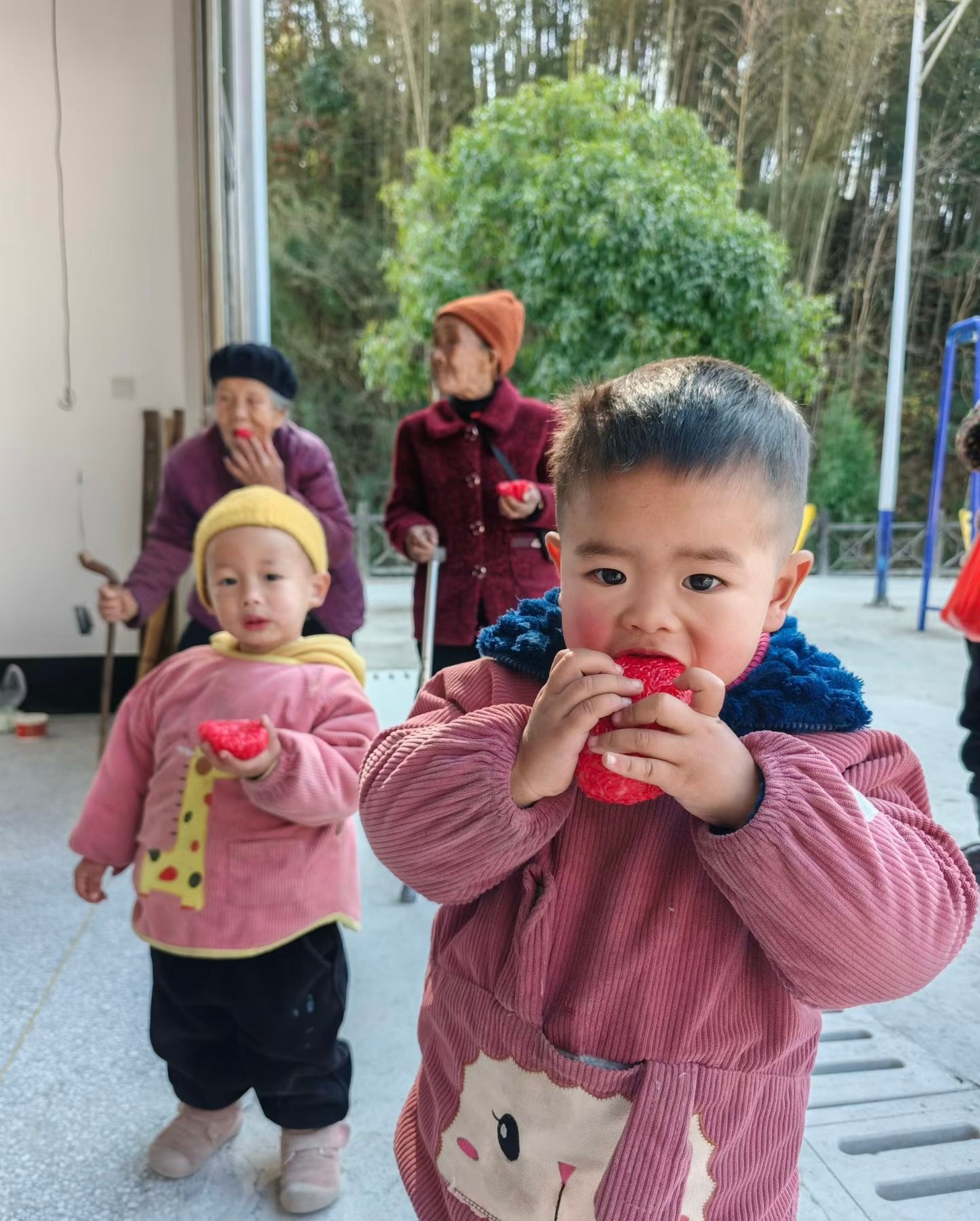 Children enjoy red rice cakes in Wengbei Village, Tongren City, southwest China's Guizhou Province, on January 8, 2026. /Tongren Media Convergence Center