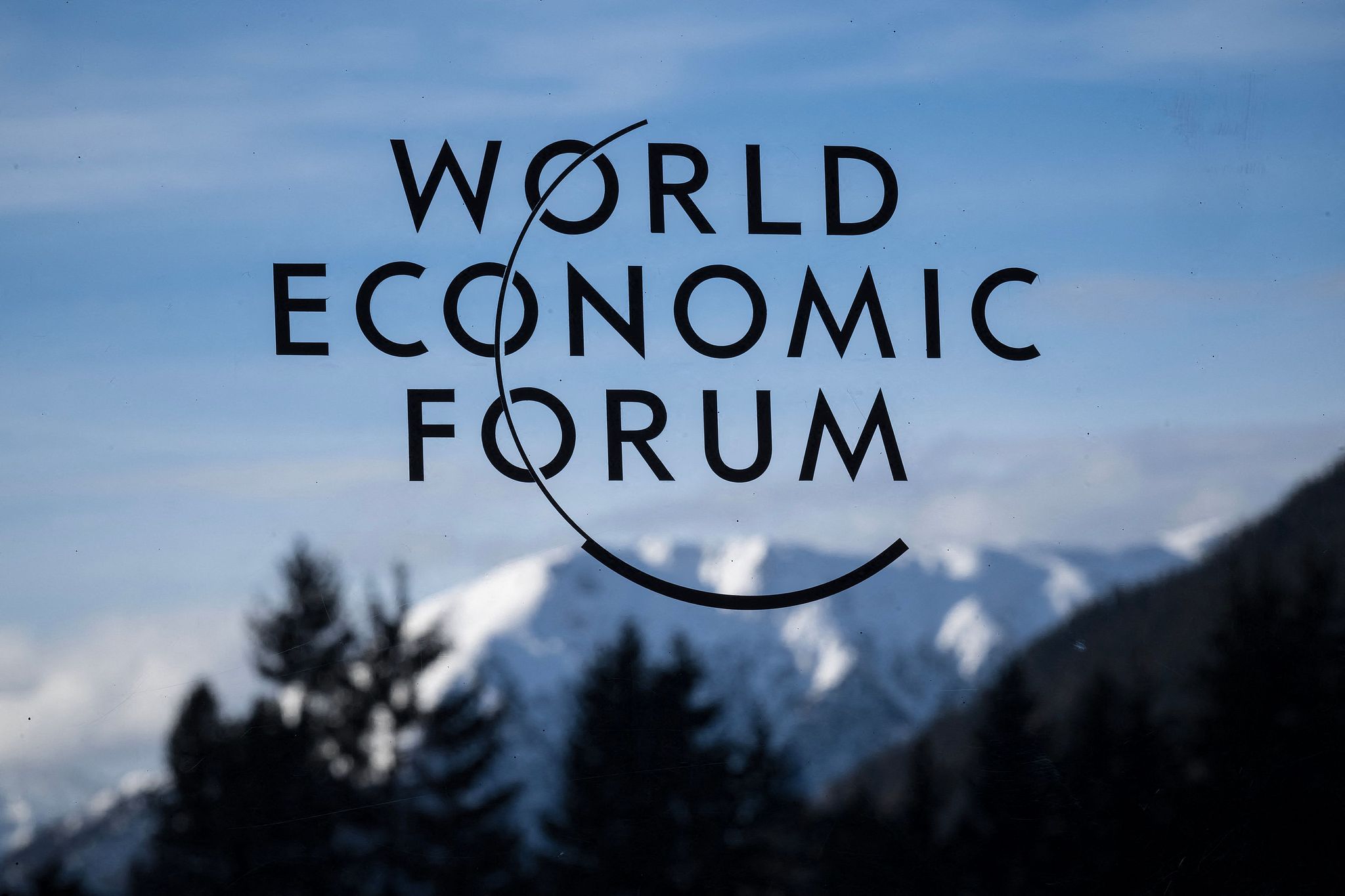 A logo of the World Economic Forum (WEF) with mountains in the background during the WEF annual meeting, in the Alpine resort of Davos, Switzerland, January 20, 2025. The WEF annual meeting in 2026 will take place from January 19 to January 23. Fabrice Coffrini/AFP