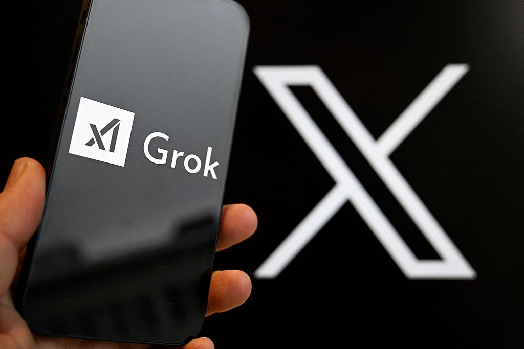 A smartphone screen displays the Grok logo, against the backdrop of the X logo. /CFP