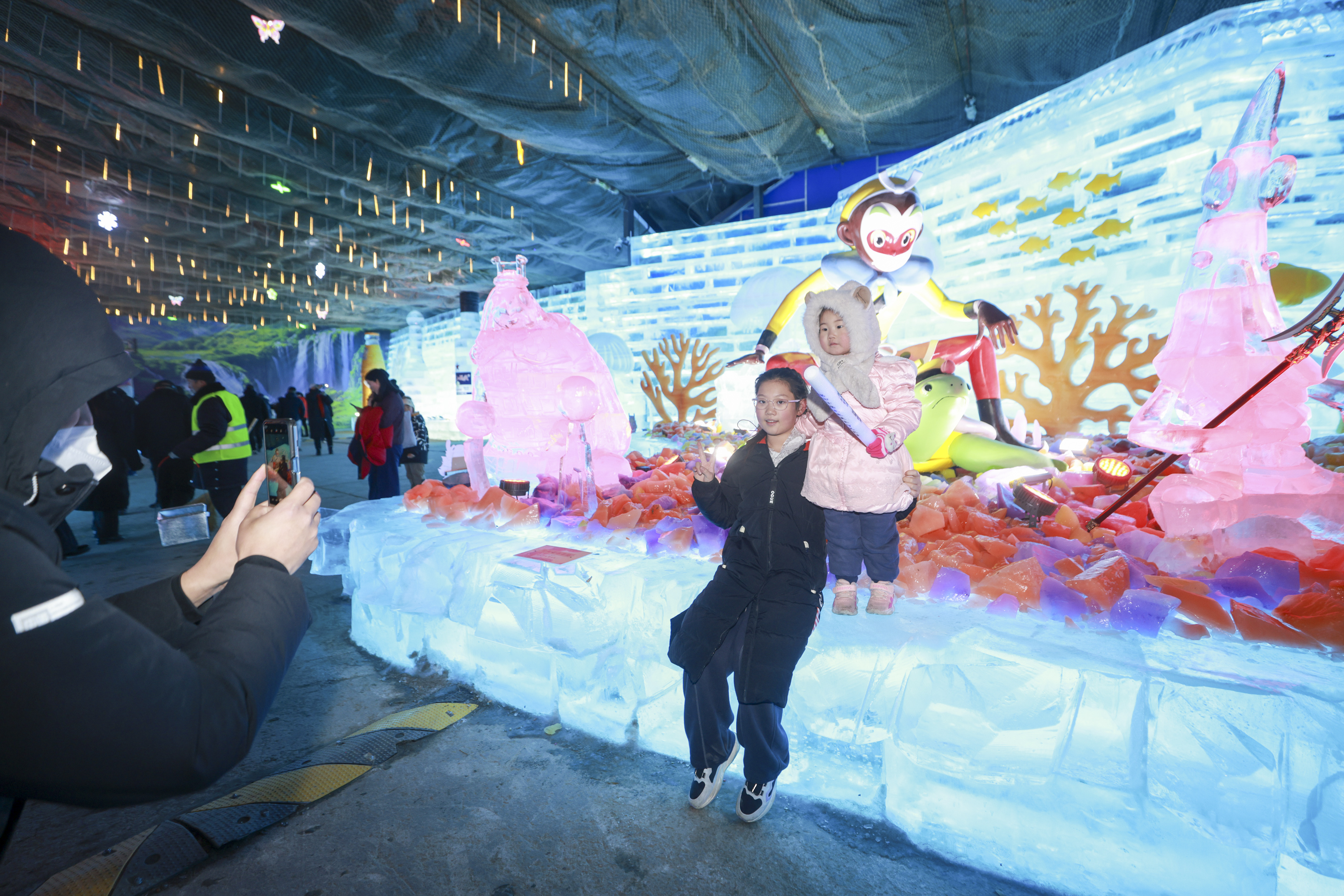 Visitors pose for photos with ice sculptures featuring characters from the classic Chinese animated film 