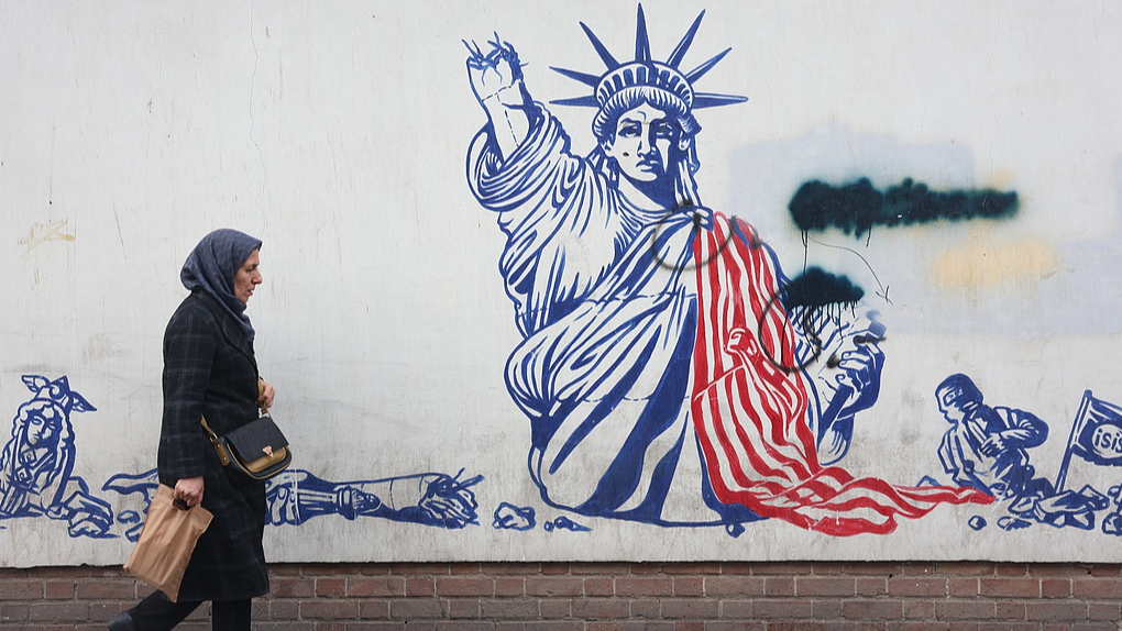 Iranians walk past an anti-U.S. mural on a street in Tehran, Iran, January 3, 2026. /VCG