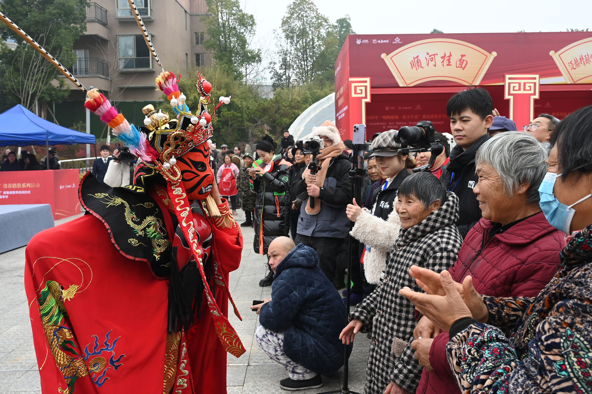 A Sichuan Opera performer interacts with audience members at Fan Changjiang Cultural and Tourism Park in Neijiang, Sichuan Province on January 16, 2025. /VCG