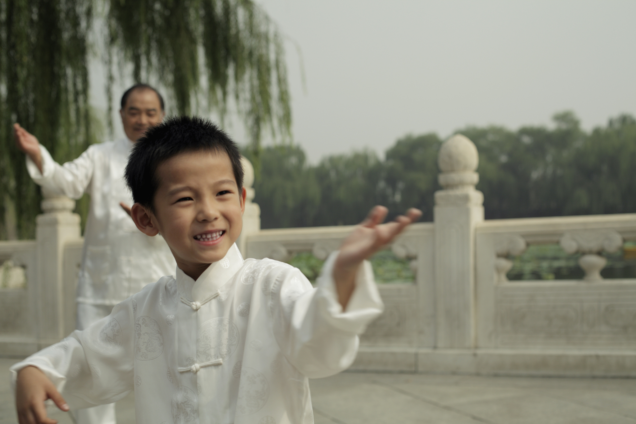 A boy practices tai chi in a park. /VCG