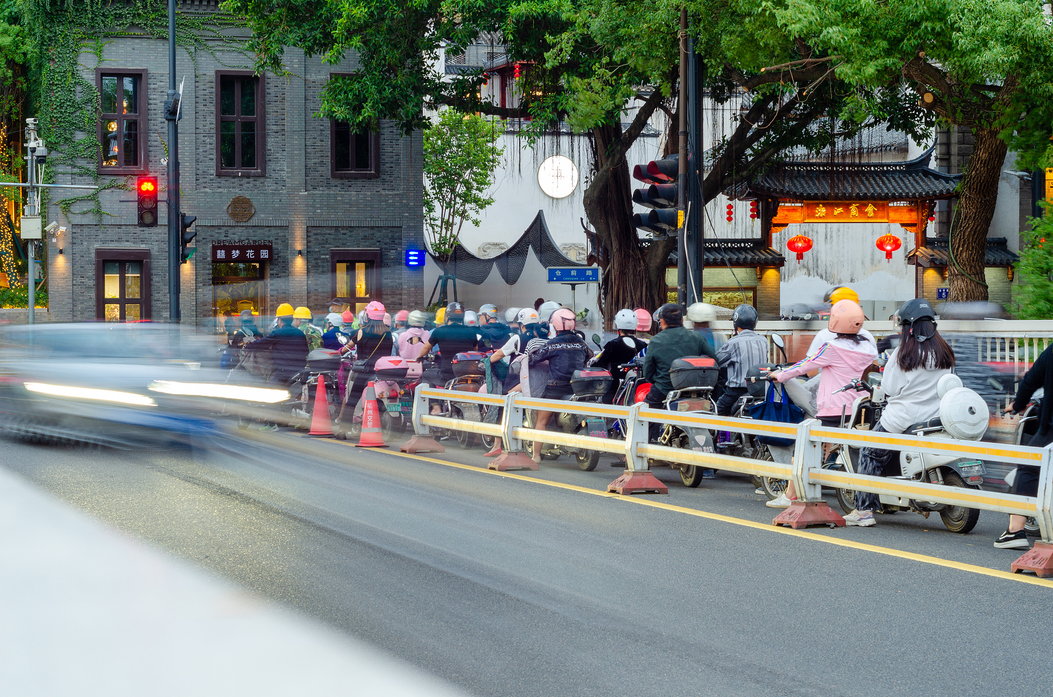 People riding electric bicycles, wearing helmets. /VCG
