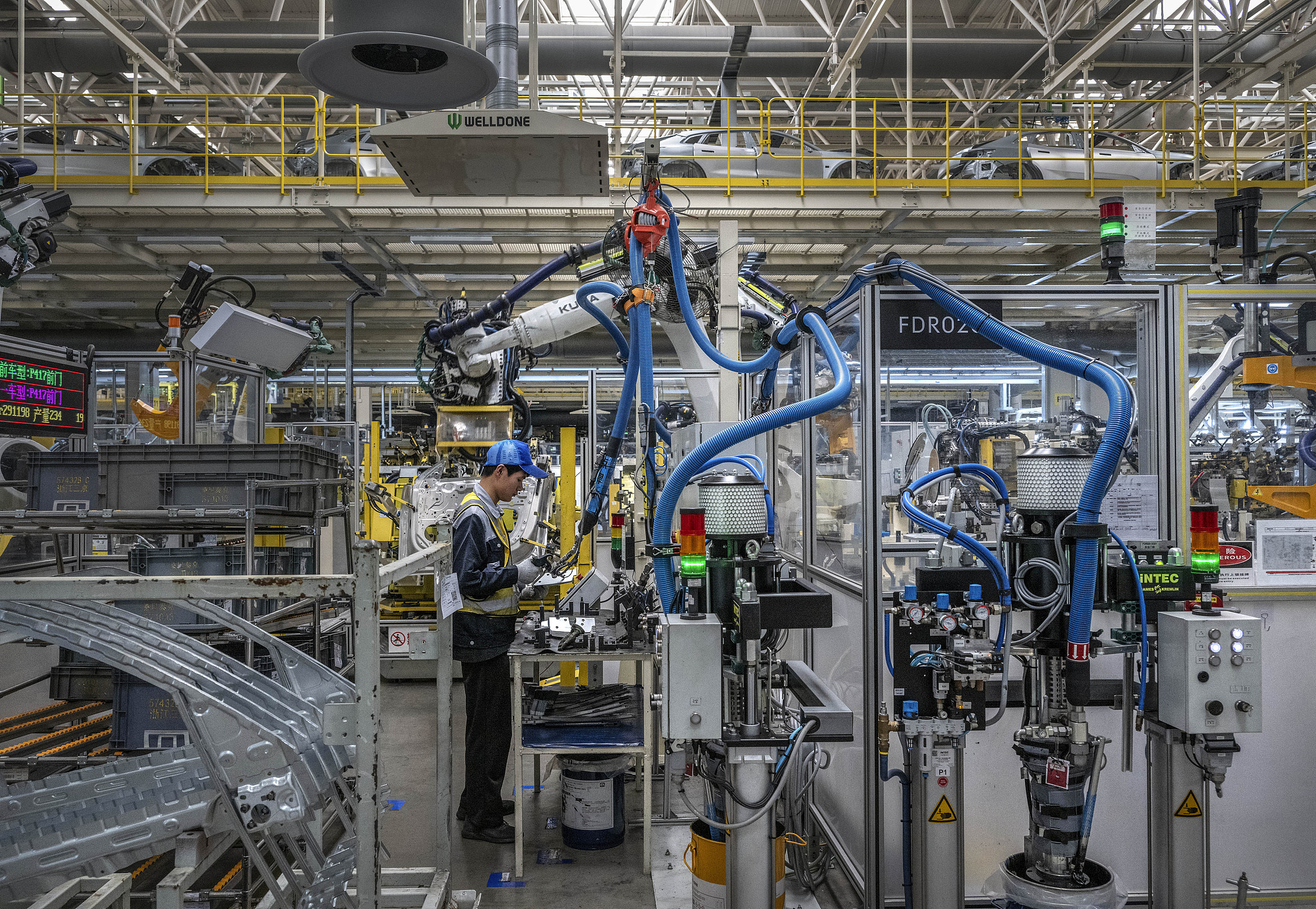 A worker monitors robotic arms on the production line at electric vehicle manufacturer Leapmotor's factory in Ningbo, Zhejiang Province on May 29, 2025./ VCG