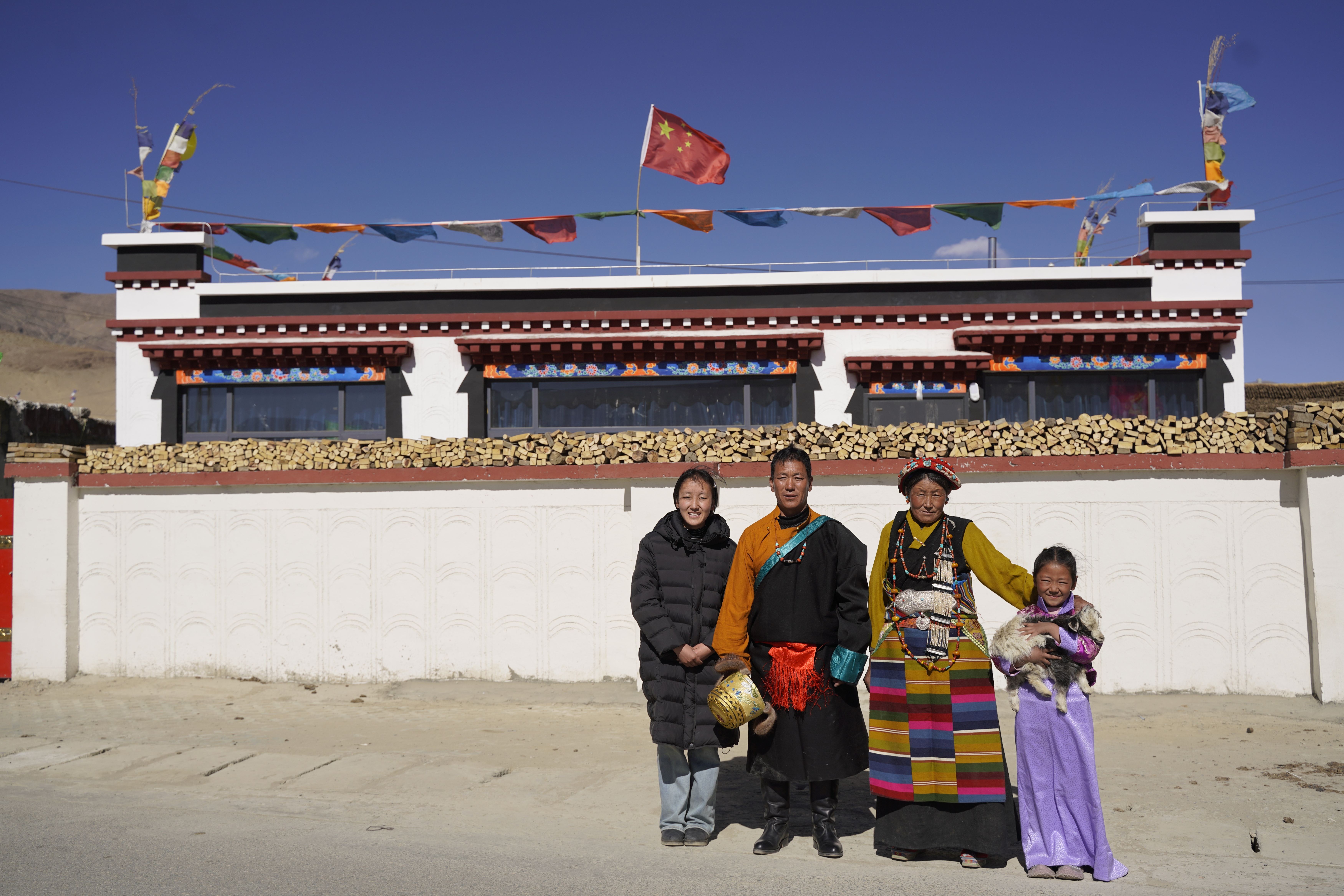Tsewang Jamsan's family has their photo taken in front of their new house in Xigaze, Xizang. /CMG
