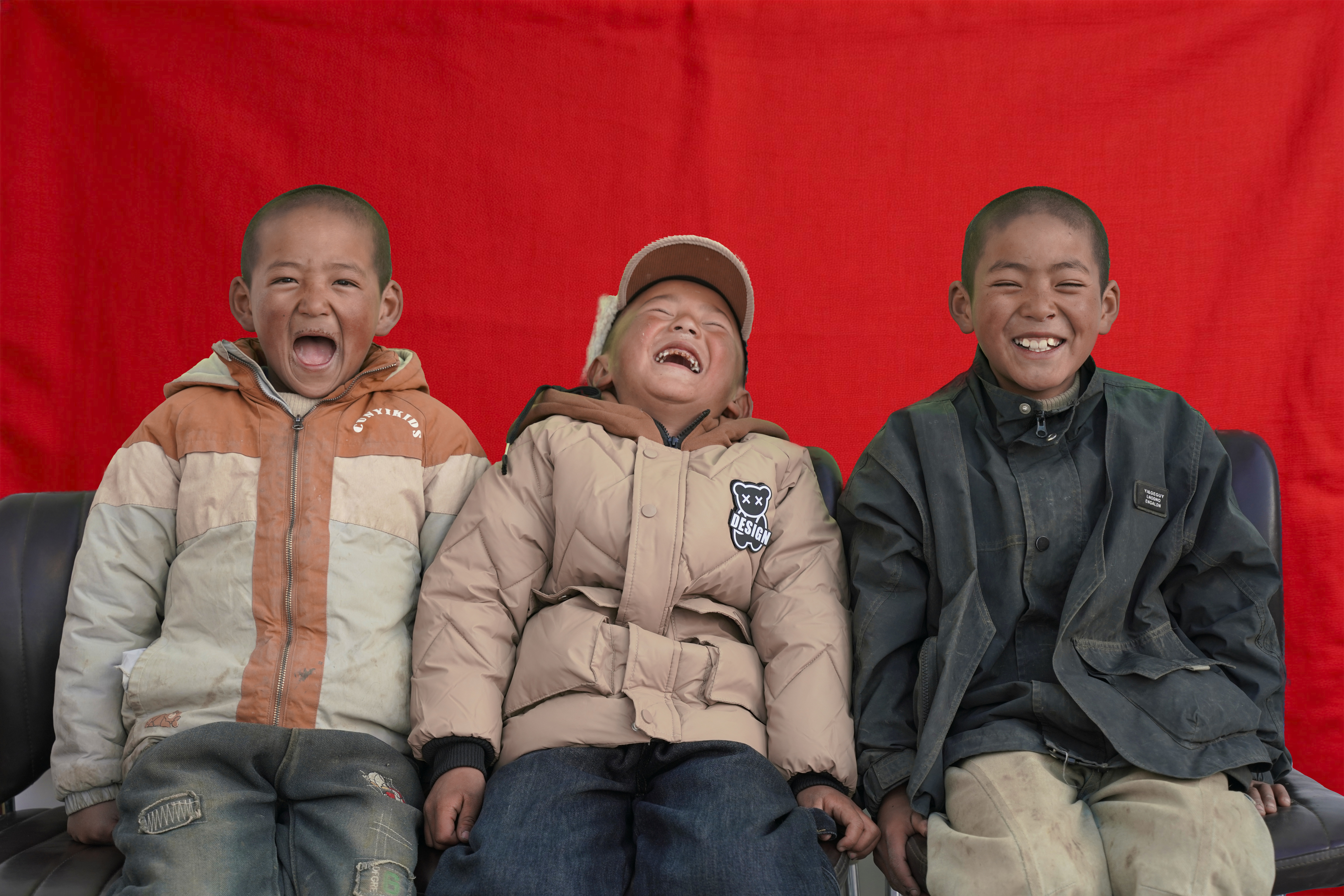 Three children in Xigaze, Xizang, smile in front of the camera. /CMG