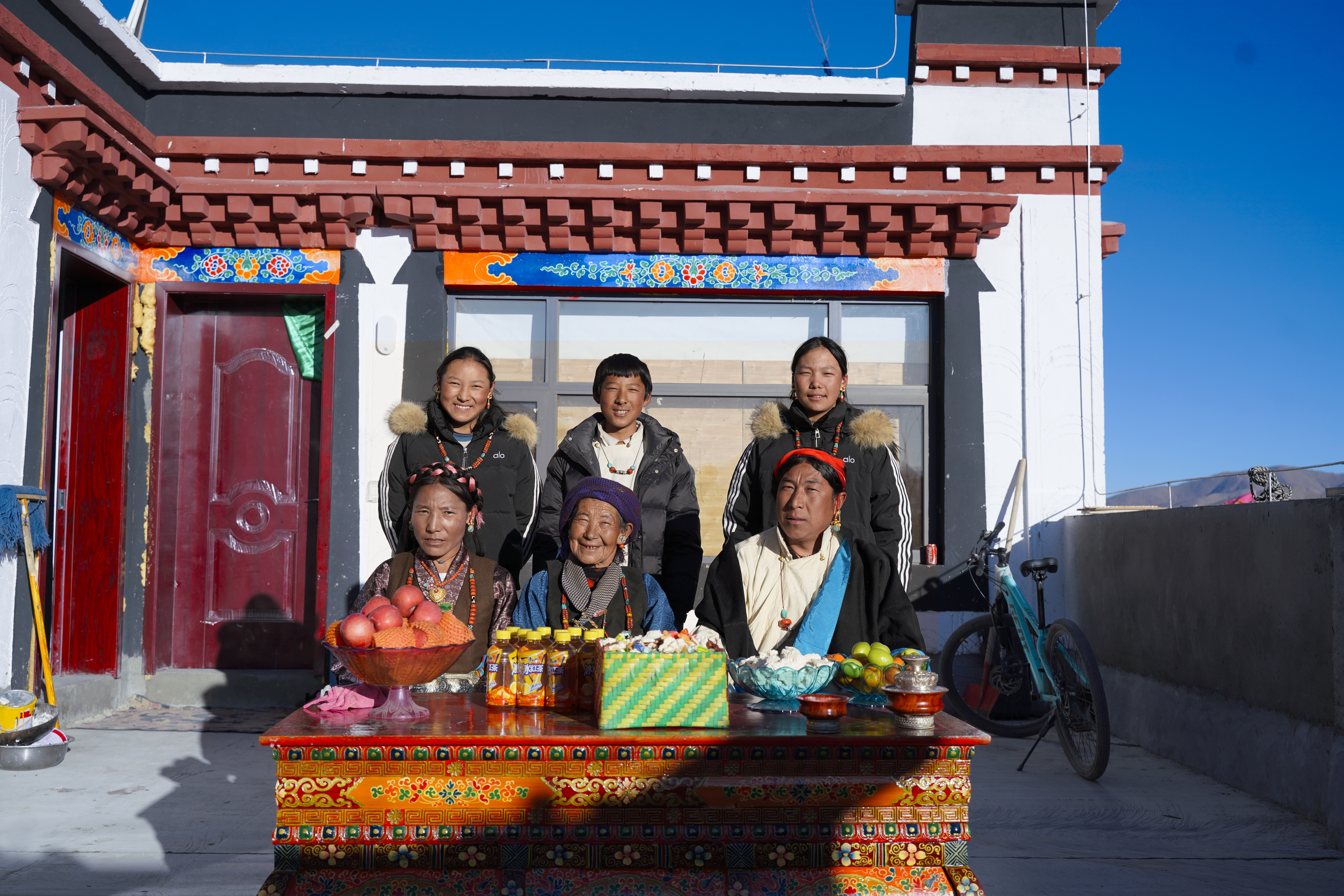 Guru's family poses for a photo on the second floor of their newly rebuilt home, celebrating the new year in Xigaze, Xizang. /CMG
